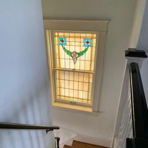 a stained glass window in a room with a staircase