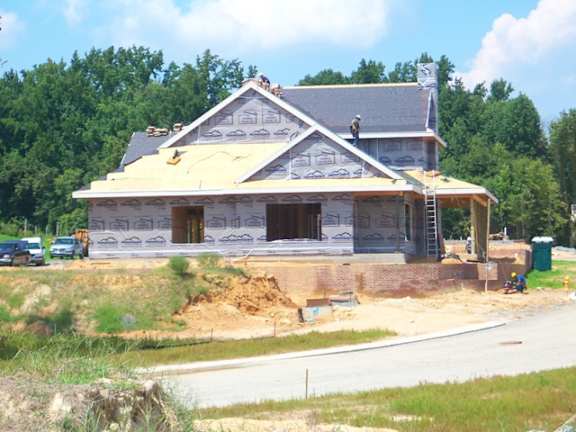 A house under construction with a roof partially installed.