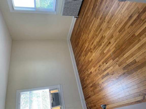 a room with a wood floor and a ceiling and a window