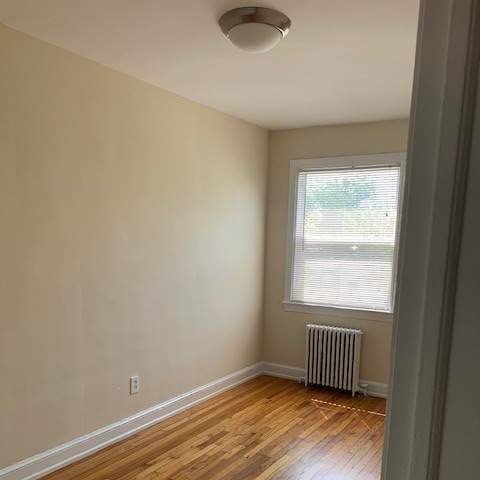 an empty room with a wooden floor and a window