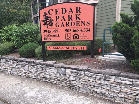 a sign for cedar park gardens in front of a building