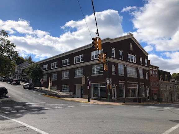 a large building on the corner of a street with traffic lights