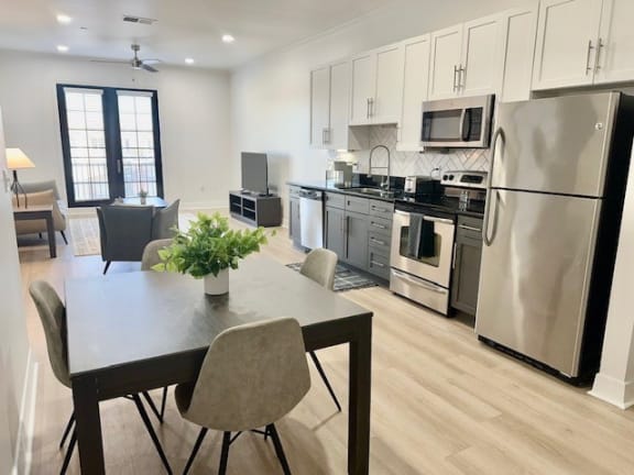 a kitchen with stainless steel appliances and a table with chairs