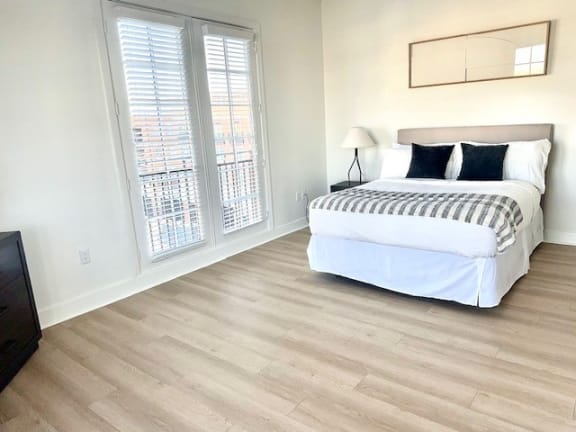 a bedroom with a bed and two windows