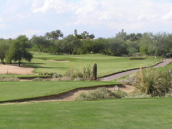 a golf course with green grass and a creek