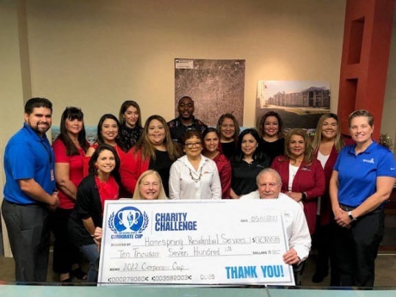 a group of people posing with a donation check