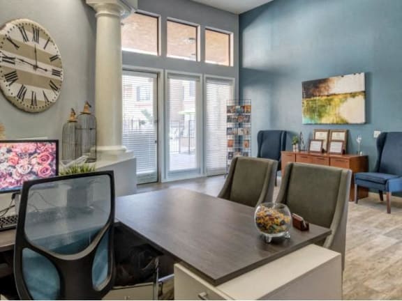Ingleside Apartments Leasing Office desk with side chairs and blue accent wall