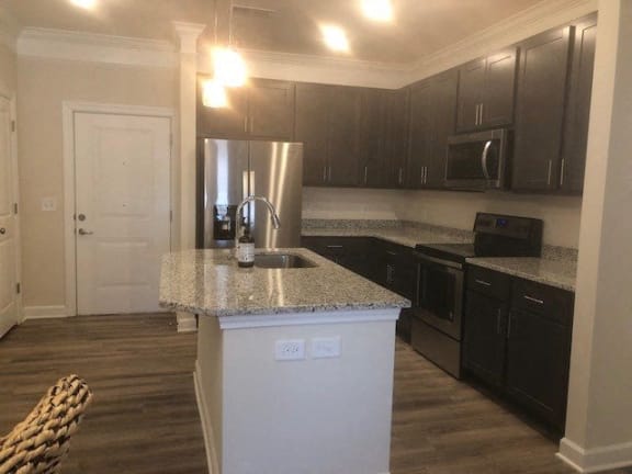 A kitchen with a granite countertop and stainless steel appliances.