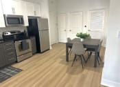 Thumbnail 3 of 13 - a kitchen with stainless steel appliances and a table and chairs