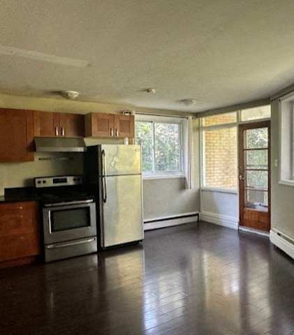 an empty kitchen with stainless steel appliances and large windows