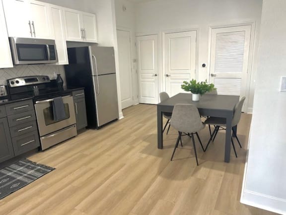 a kitchen with stainless steel appliances and a table and chairs