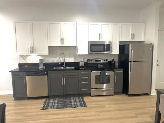 a kitchen with stainless steel appliances and white cabinets