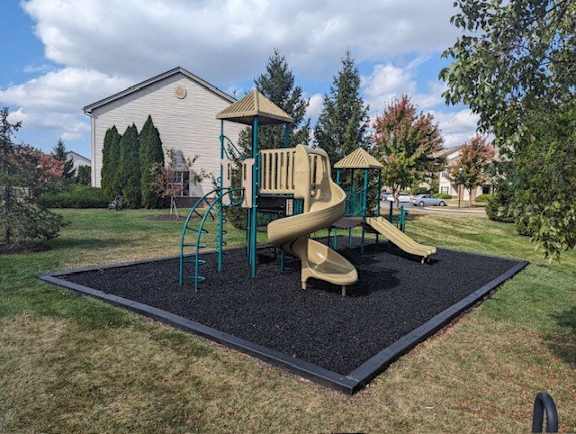 A playground with a slide and a wooden structure.
