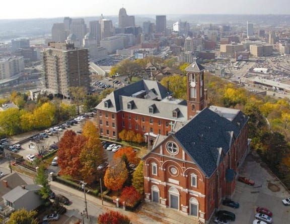 an aerial view of a church with a city in the background