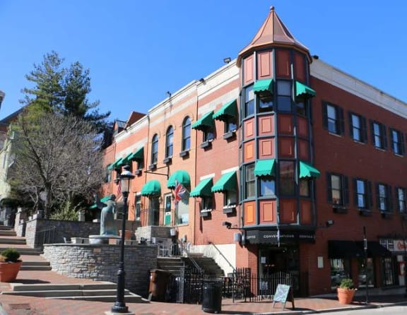 a red brick building with green umbrellas