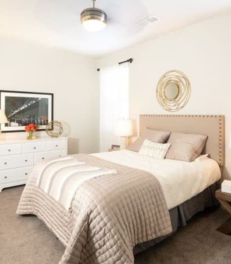 a bedroom with a large bed and a ceiling fan