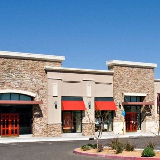 a brick building with red awnings and a parking lot