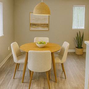 A dining room with a round table and chairs.