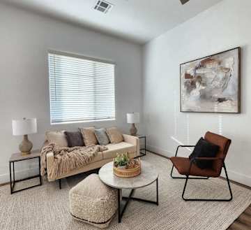 Furnished apartment living area shown — representative home at Zora Encanto.