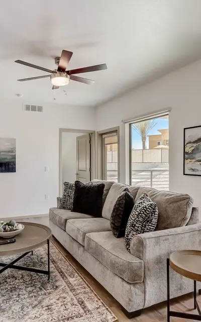 A living room with a blue couch and orange pillows.