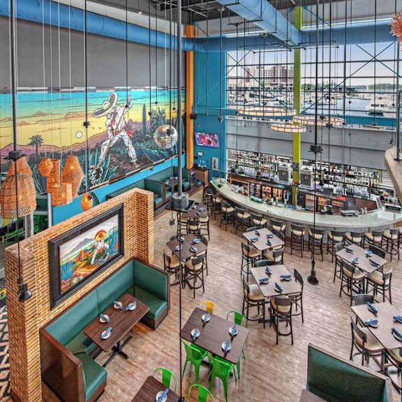 A restaurant with a large mural of a man on a beach.