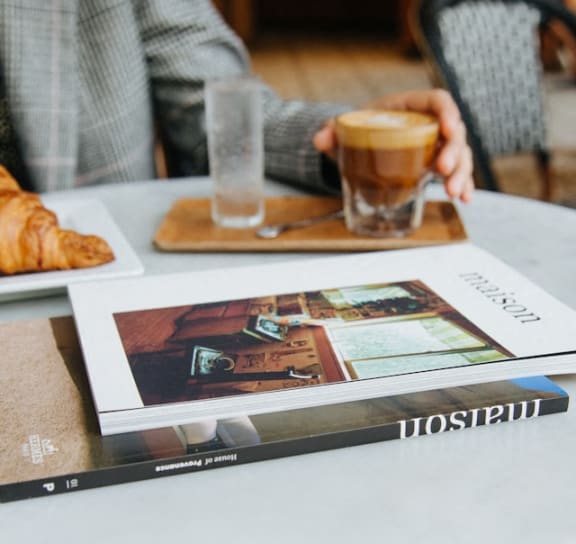 a table with a magazine and a cup of coffee on it