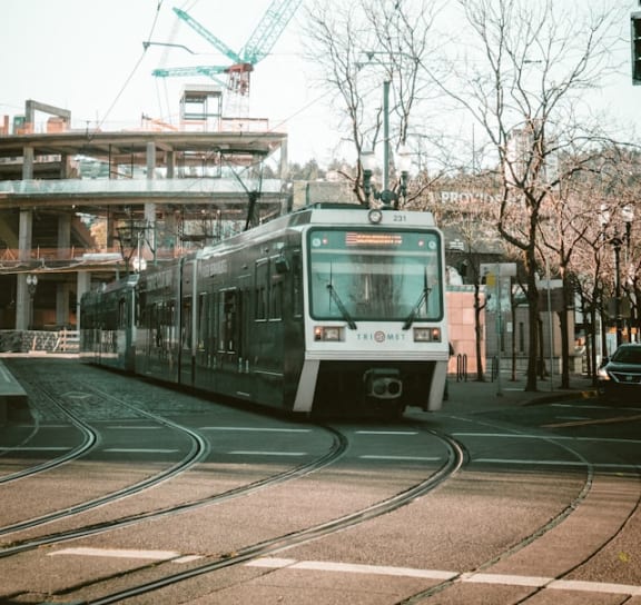 a train on a city street with a crane