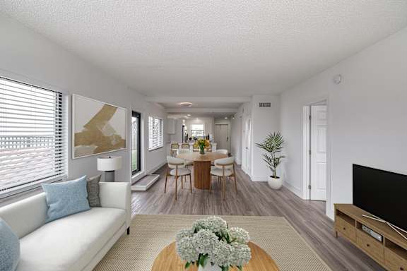 a living room and dining room with a table and chairs