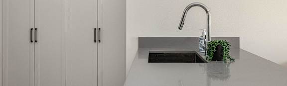 a kitchen with white cabinets and a sink and a faucet