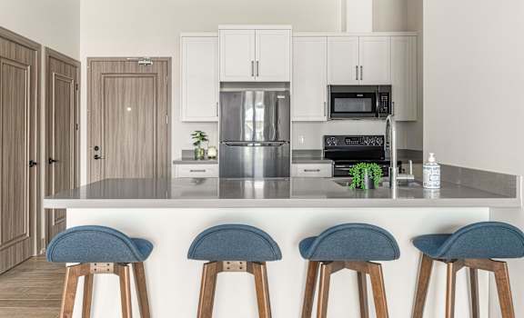 a kitchen with a counter top with four stools at 2274 Princess St., Kingston, ON, K7M 3G4