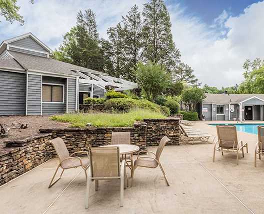 A backyard with a pool and patio furniture.
