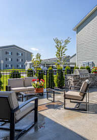 A patio with a table and chairs under a green umbrella.