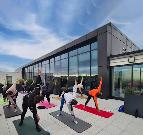 A group of people practicing yoga on a rooftop.