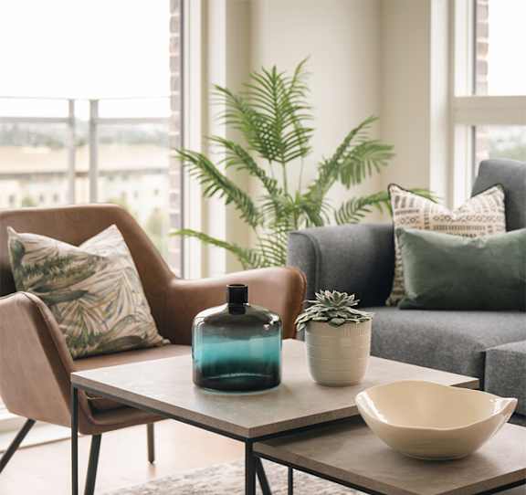 A blue bottle sits on a table between two chairs.