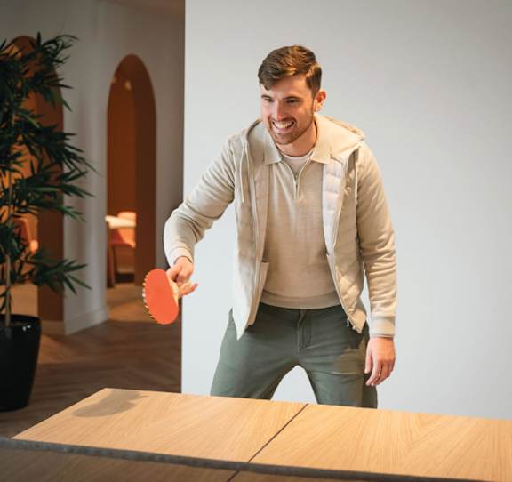 A man is playing ping pong in a room at Cherrywood Apartments, D18 VY3V, DUBLIN 18