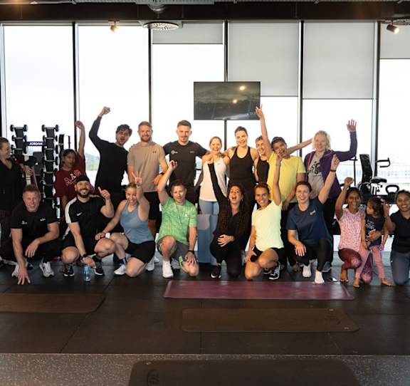A group of people are posing for a photo in a gym.