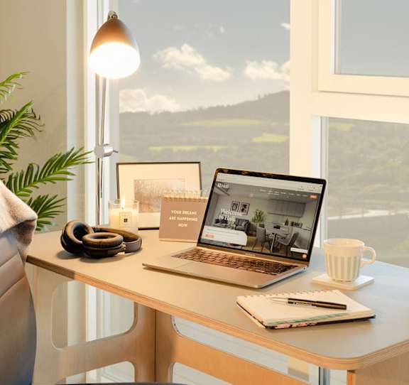 A laptop on a desk with a notebook, a cup, and a lamp at Cherrywood Apartments, D18 VY3V, DUBLIN 18