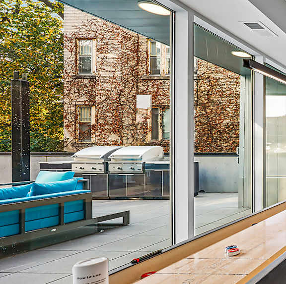 Community game room with shuffleboard and modern seating at Pure Lowry Apartments, Minneapolis, MN 55405