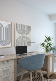 a living room with two chairs and a desk with a laptop