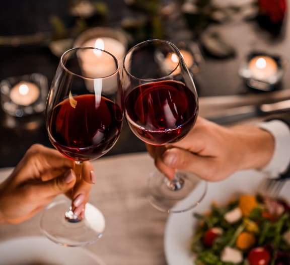 two people holding up wine glasses in a restaurant
