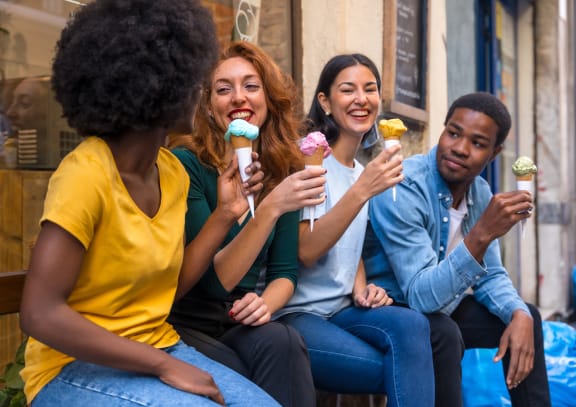 a group of people sitting on a bench eating ice cream