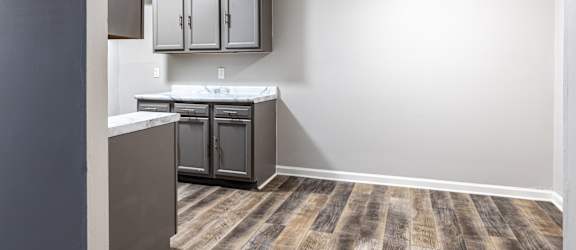 an empty kitchen with a ceiling fan and a sink