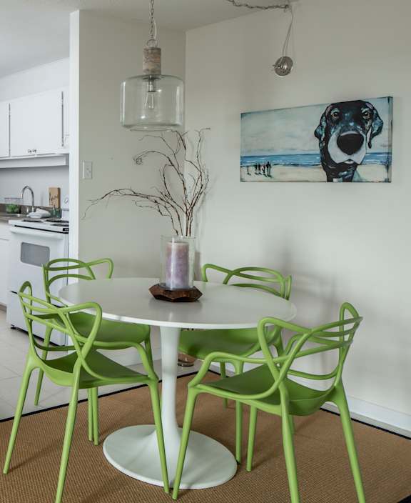 A living room with a white couch and a dining table.
