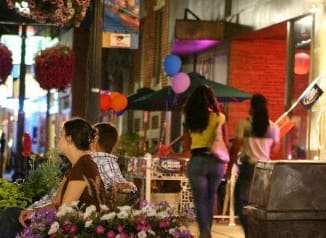 a group of people walking down a city street at night