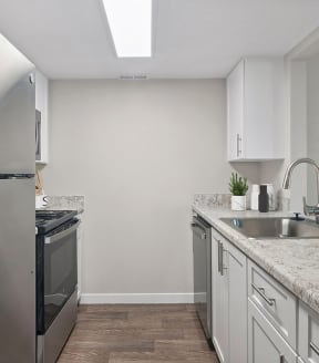 Model Kitchen with White Cabinets and Wood-Style Flooring at Overlook Point Apartments in Salt Lake City, UT-SMLAM.