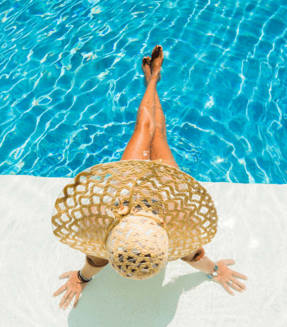 Woman wearing hat and with legs in pool at Villages at Gateway, Denver, CO