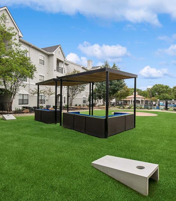Outdoor Corn Hole Area and Lounge Furniture at Hidden Creek Apartments located in Lewisville, TX-SMLAM.