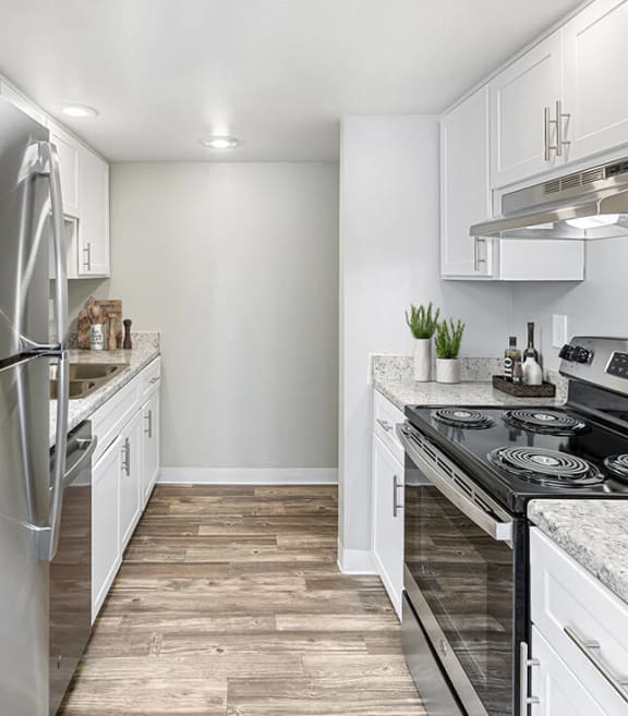 Model Kitchen with White Cabinets and Wood-Style Flooring at Lakeside Casitas Apartments located in Tucson, AZ-SMLAM.