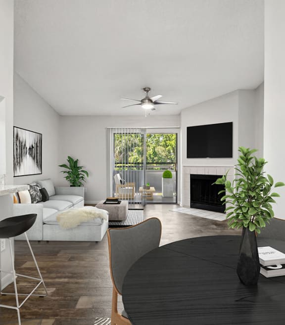 Model Dining Room with Wood-Style Flooring and View of Living Room with Patio Accessibility at Rosehill Preserve Apartments located in Orlando, FL-SMLAM.