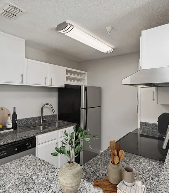 Model Kitchen with White Cabinets and Wood-Style Flooring at Shadow Ridge Apartments in Riverdale, GA-SMLAM.